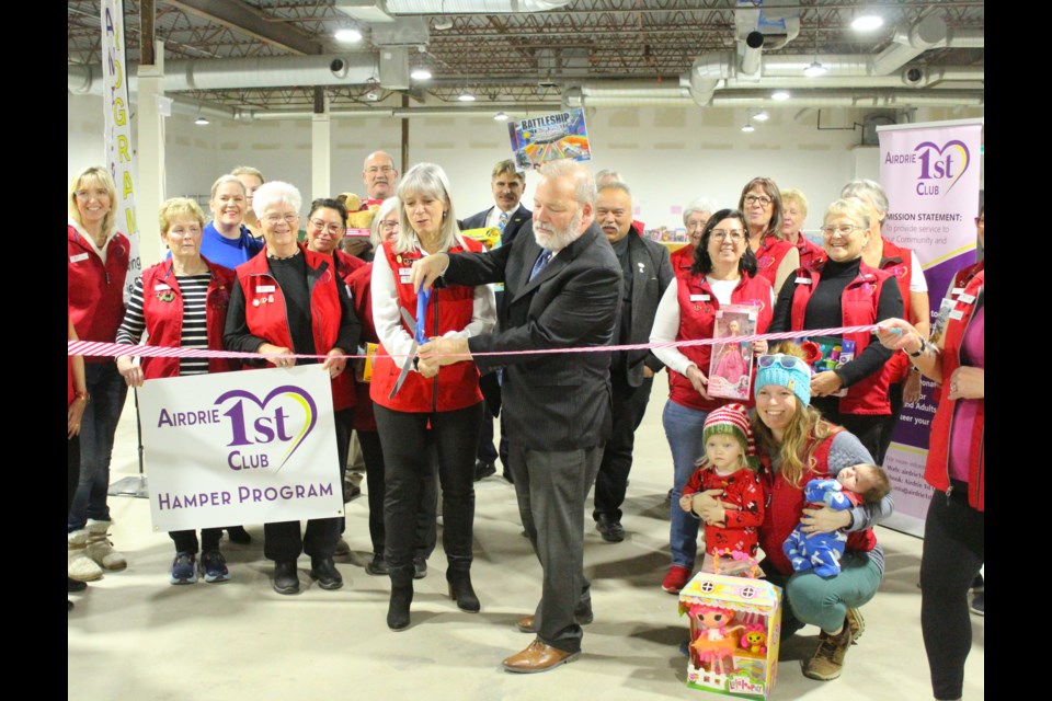 Mayor Peter Brown with Airdrie 1st Club president Jo-El Buerlen cut the ribbon to officially kick off the Christmas Hamper campaign for 2023.