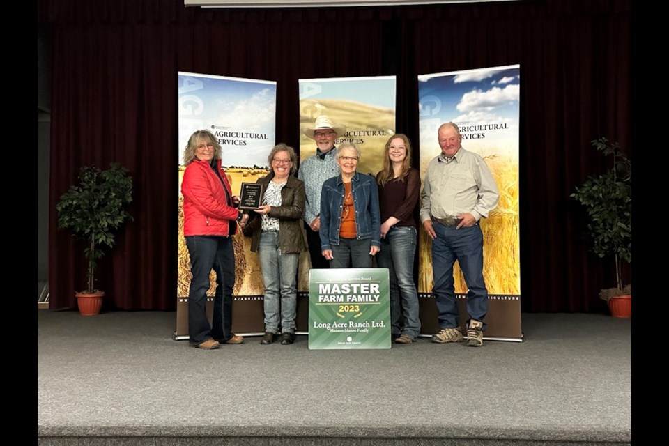 RVC reeve Crystal Kissel hands over the 2023 Master Farm Family award to Tracy Hanson, Earl Munro, Sandra Hanson, Dr. Brennan Munro, and Bonar Hanson.