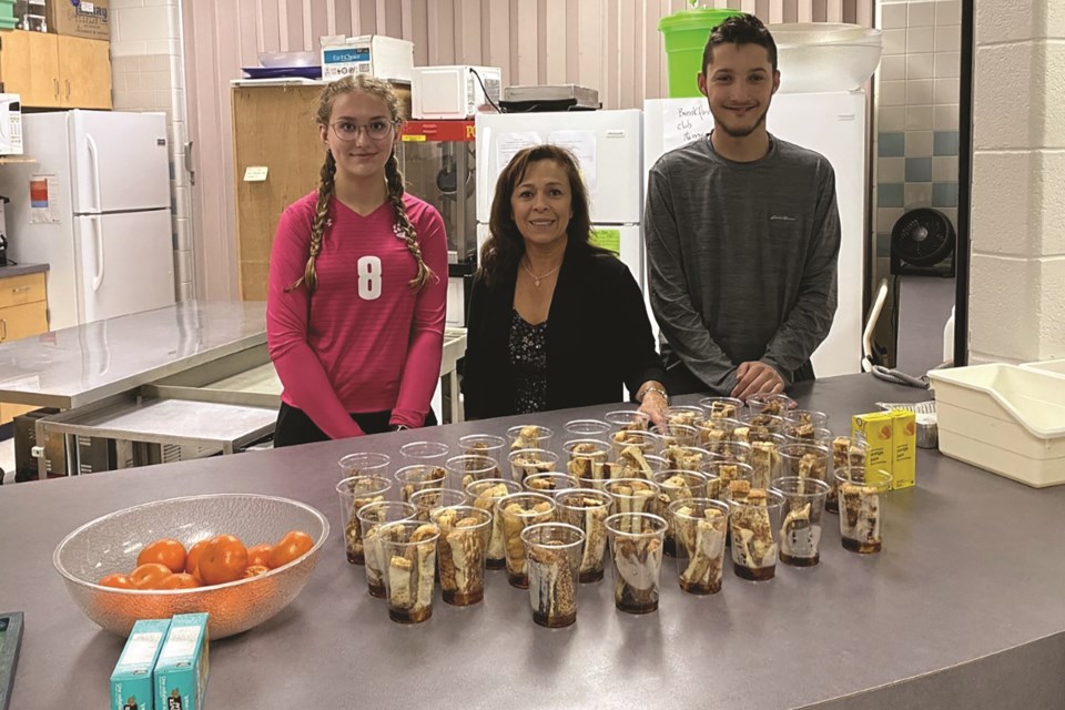 St. Martin de Porres High School in Airdrie recently received a $10,000 grant to be used towards enhancing its breakfast program. Education assistant Carolina Prieto is pictured (centre) alongside breakfast club student volunteers. 