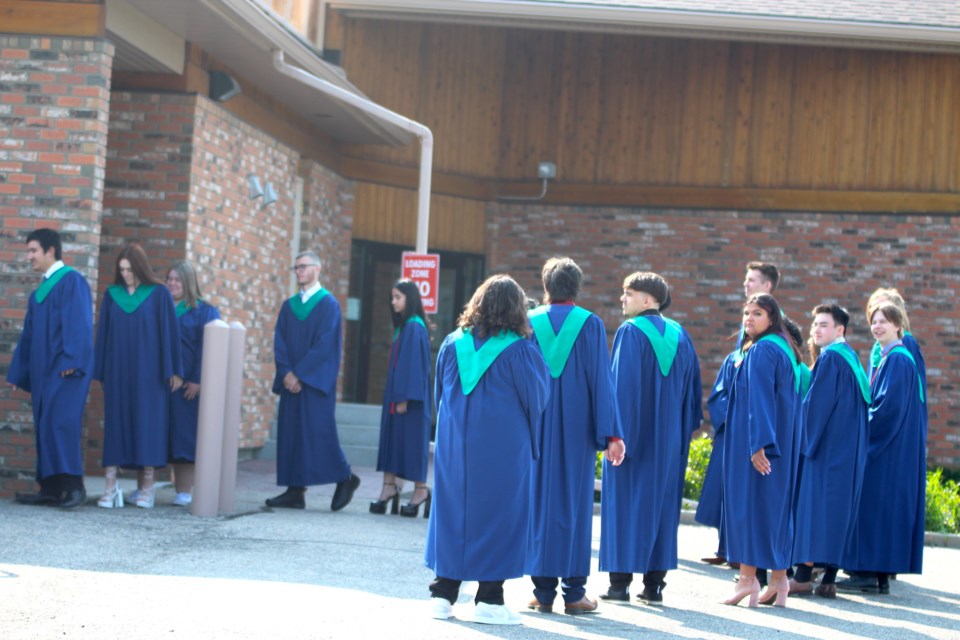 St. Martin de Porres 2023 grad class waits outside St. Paul's Catholic Church in Airdrie for their grad ceremony to begin on May 26.