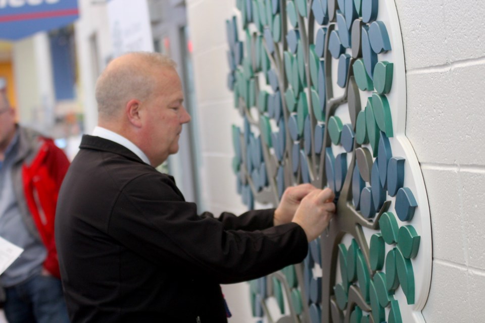 Mayor Peter Brown puts the first leaf on the Airdrie and District Community Foundation's "Donor Tree" at Genesis Place on Feb. 28.