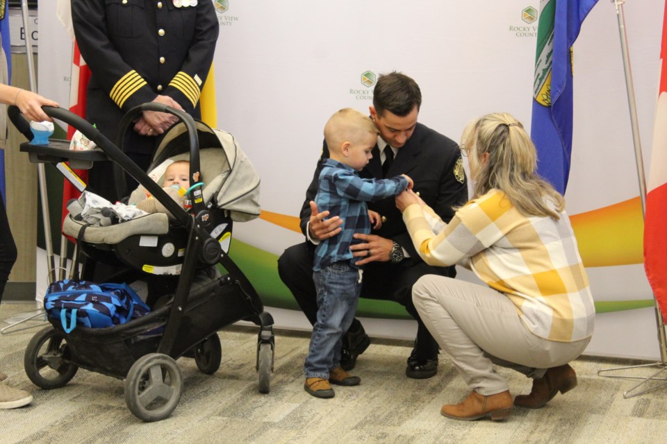 Firefighter Matt McLane receives his 12-year service medal from his young son during a special ceremony at RVC  Hall on Saturday.