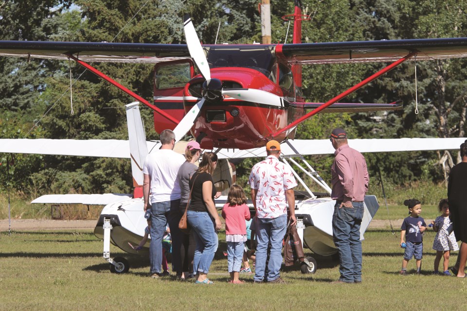 Visitors to the 2021 Alberta AIr Tour gather around a floatplane to meet and greet the pilot at the Airdrie Air Park on Aug. 28. 