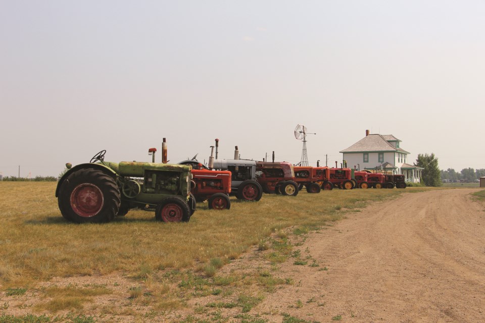 A trail of tractors leads to an authentic pioneer home at Pioneer Acres Museum on July 24. 