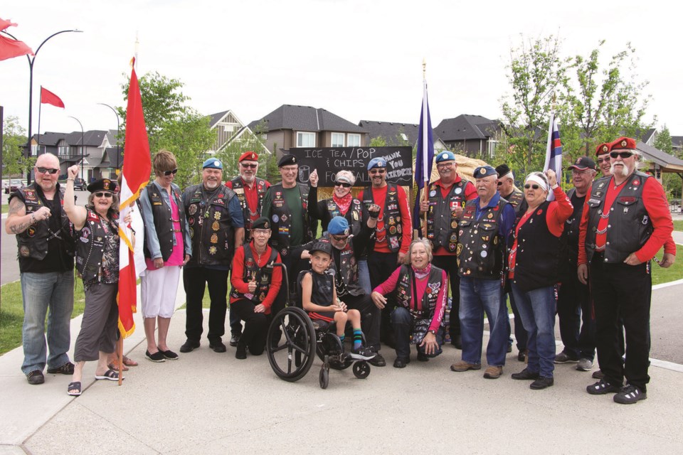 Easton Grant (centre) received $400 from the Veterans Brotherhood Canada June 26. The club donated the money to help grant purchase a custom BMX bicycle, and Grant plans to donate any remaining funds to the Alberta Children's Hospital. Photo by Jordan Stricker/Airdrie City View.