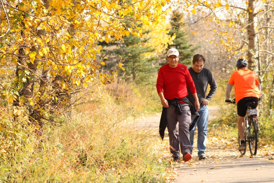 Walkers trek through Riverfront Park in Cochrane on a warm fall Friday afternoon.