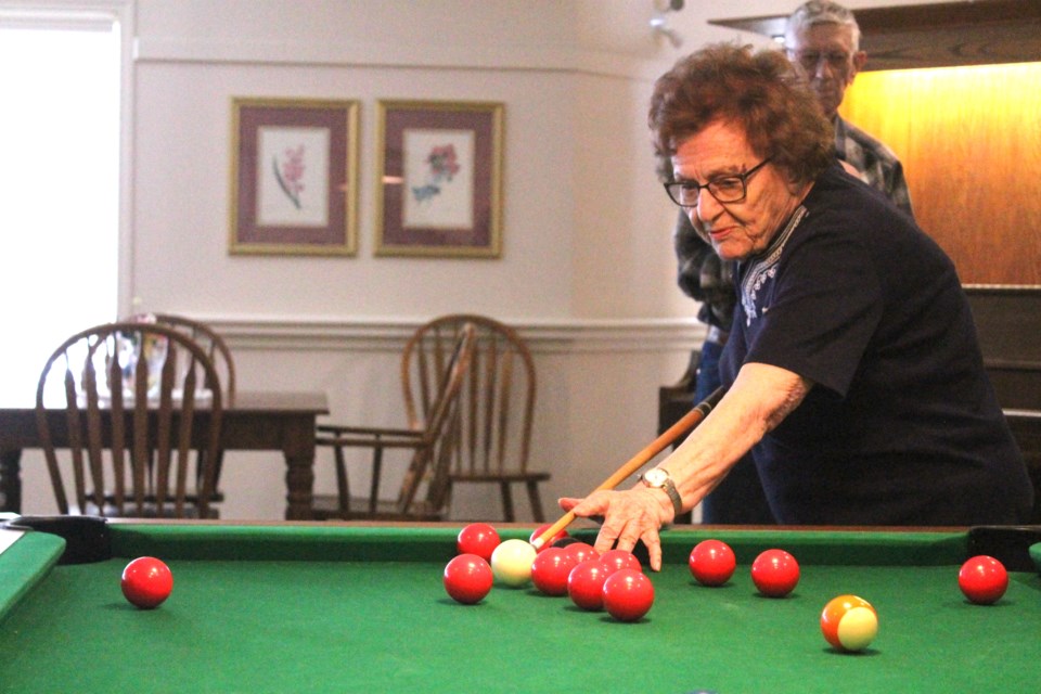 Centenarian Jean Ternowetsky lines up her first shot of the day at the Fletcher Village pool table on Feb. 28.