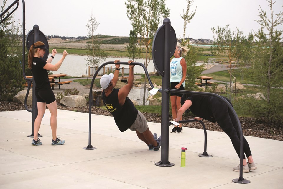 A group of people exercise using the outdoor gym equipment at the new Bayview Park in southwest Airdrie.                                