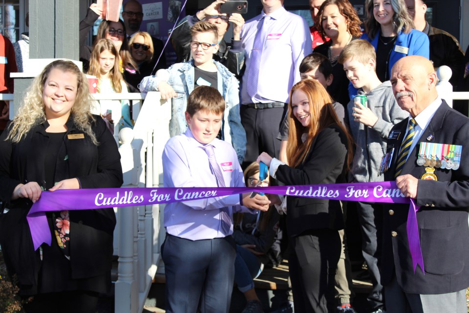 Jack Hunter and Faith Dickinson (centre left and centre right) cut the ribbon to mark the opening of the Airdrie chapter of Cuddles for Cancer. Photo by Scott Strasser/Rocky View Publishing