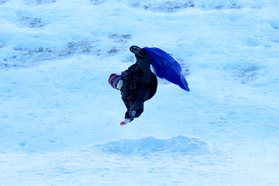 A young tobogganer in Airdrie flies off a jump on the hill behind W.H. Croxford High School on Jan. 3. 
