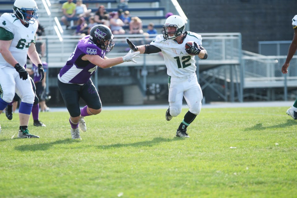 Airdrie Irish running back Connor Lutz puts up a stiff arm against a Wolfpack linebacker June 1. Photo by Scott Strasser/Rocky View Publishing