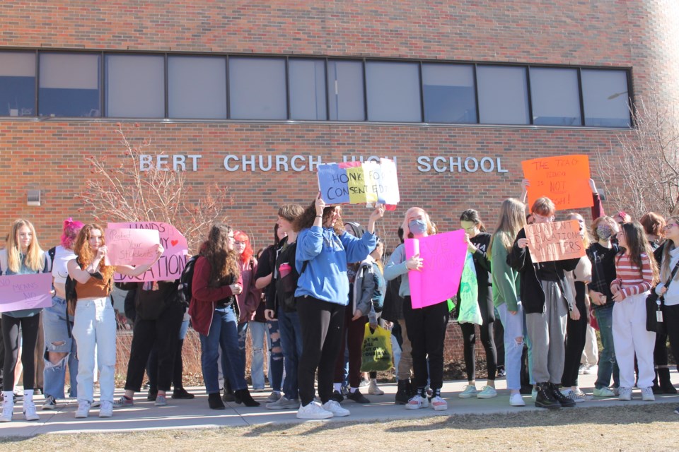 Students hoist signs at the front of Bert Church High School on April 7, to protest what they argue is a lack of focus on sexual consent in the health curriculum.