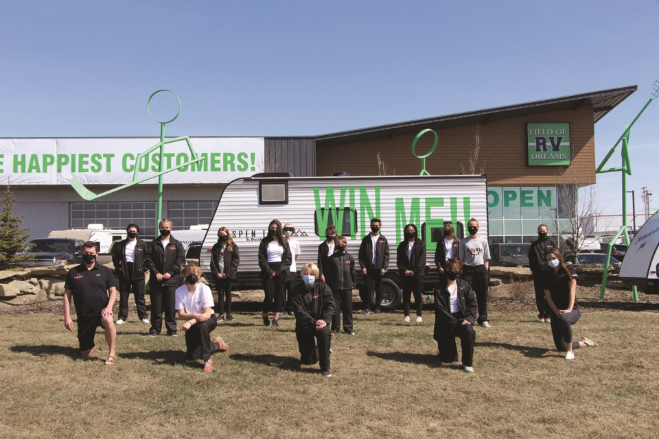 Members of the Airdrie Phoenix Swim Club pose in front of Field of Dreams RV in Airdrie on April 17 to promote its ongoing fundraiser.