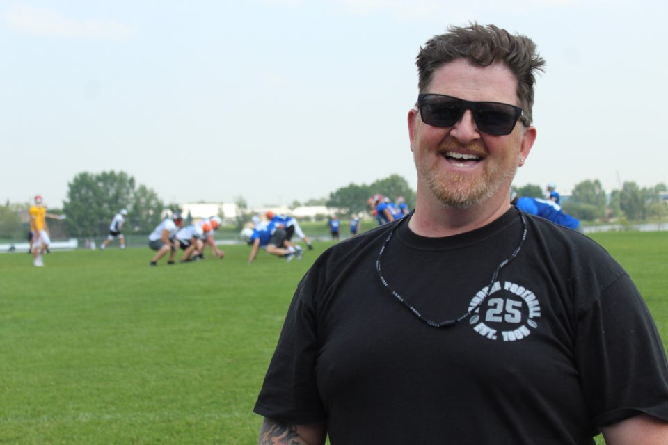 Long-time Airdrie football coach Tyrell Rohl poses in front of a Football Alberta Summer Series practice at Ed Eggerer Athletic Park on July 16.