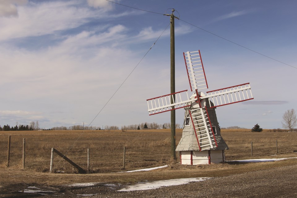 A miniature windmill adorns the entrance to a farmer's homestead along road 566, east of Balzac.