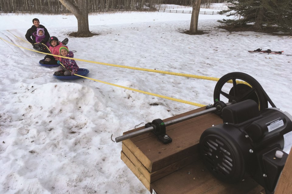 Springbank resident Ian Park built a mechanical 300-foot tow rope for his kids to use while tobogganing down the hill in their backyard.