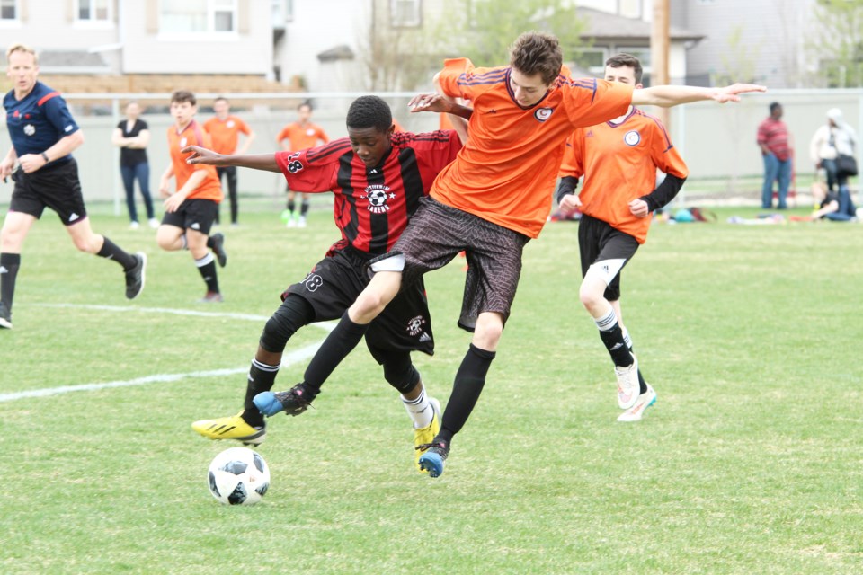 The Chestermere Lakers boys' soccer team is halfway through the 2019 regular season. With a 1-2 record, the team will want to get back to winning ways in the lead-up to the RVSA playoffs. Pictured: A Lakers player (left) tustles with a W.H. Croxford player May 14. 
Photo by Scott Strasser/Rocky View Publishing