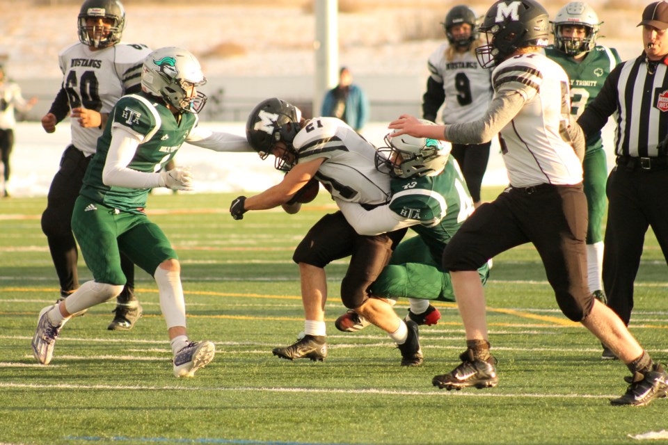 Paul Condon uses his strength to stay on his feet during the Mustangs' 48-21 loss to the HTA Knights on Nov. 4. Photo by Scott Strasser/Airdrie City View