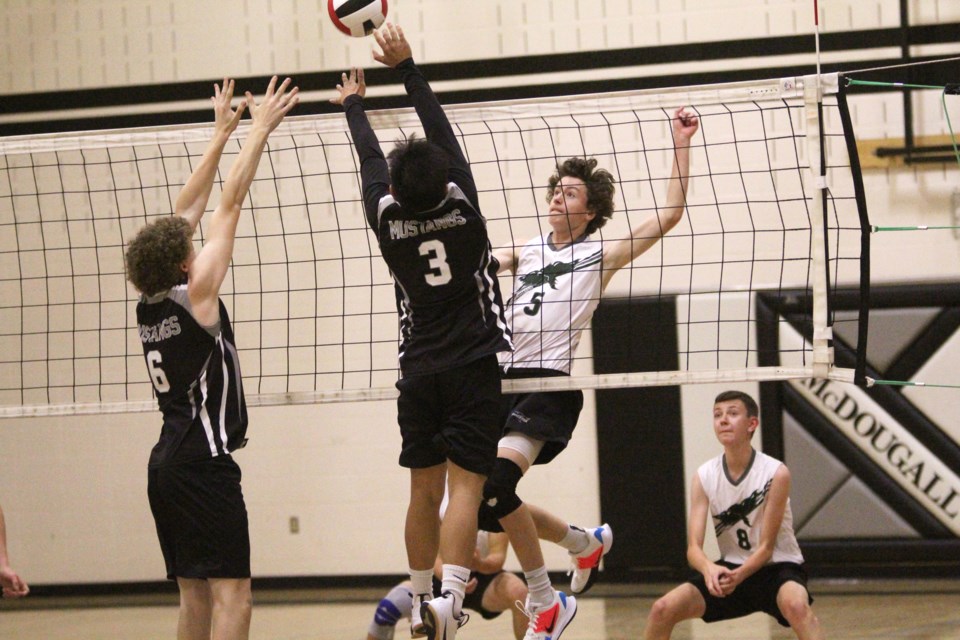 Two members of the George McDougall senior boys' volleyball team go up for a block Sept. 18, in the Mustangs' season-opener against the Springbank Phoenix. The Mustangs lost in three straight sets. Photo by Scott Strasser/Rocky View Publishing