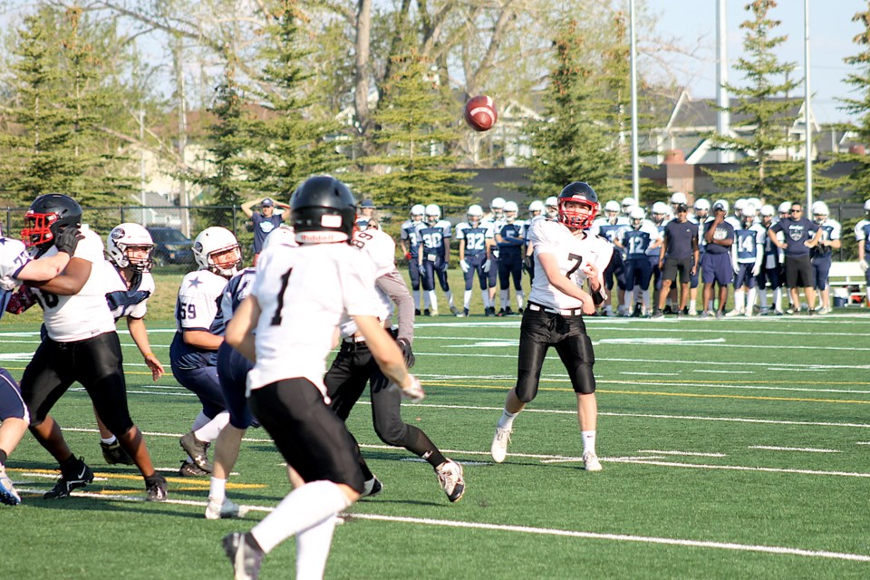 The Airdrie Raiders quarterback throws the team's first touchdown pass to Tyrell Hofland on May 12, at the end of the first quarter.