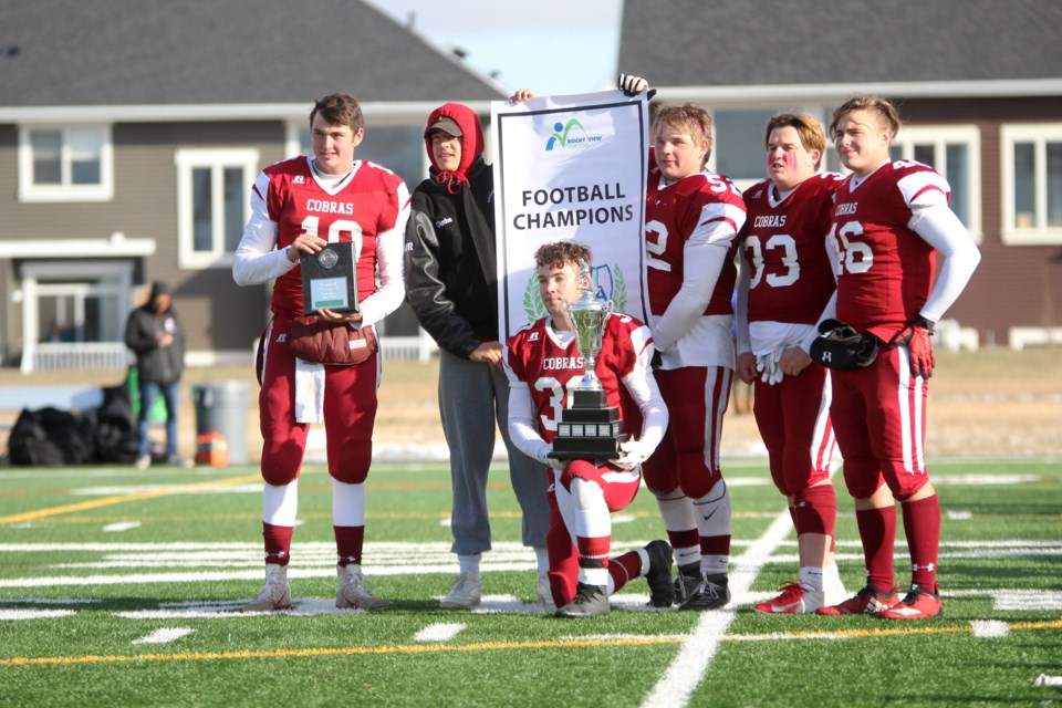 The captains of the Cochrane Cobras football team show off the banner and trophy, after the team secured its fifth consecutive Rocky View Sports Association championship Oct. 26, downing the Bert Church Chargers 31-7. Photo by Scott Strasser/Rocky View Publishing