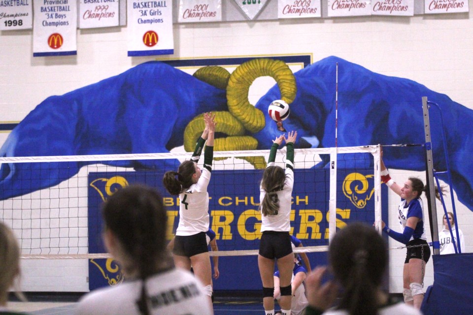 Two Springbank players attempt to block a spike from the Bert Church Chargers on Oct. 12.