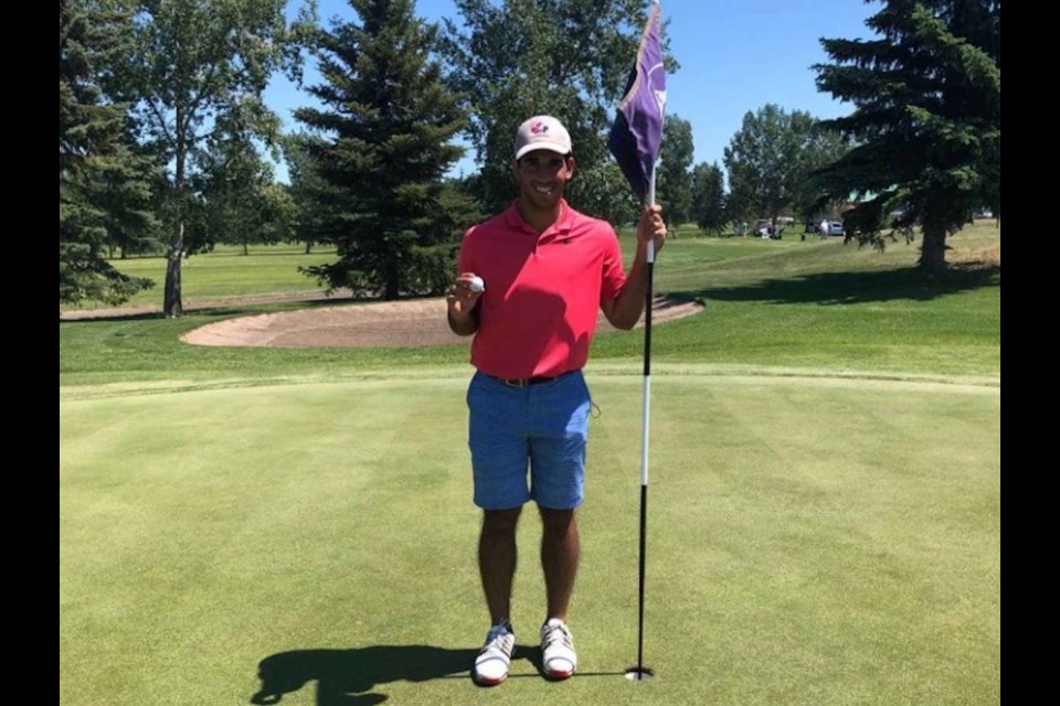 Trae Verjee poses next to the hole he scored a hole-in-one on at the Olds Central Highland Golf Course on June 29. 