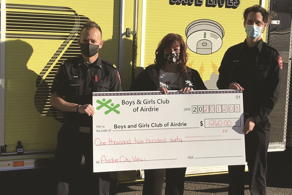 City View Publishing and the Airdrie Fire Department presented the Boys and Girls Club of Airdrie with a $1,260 cheque Dec. 3. The donation will support youth programs and was made possible through funds raised by the Firefighter Safety Card Program. Photo submitted/For Airdrie City View.