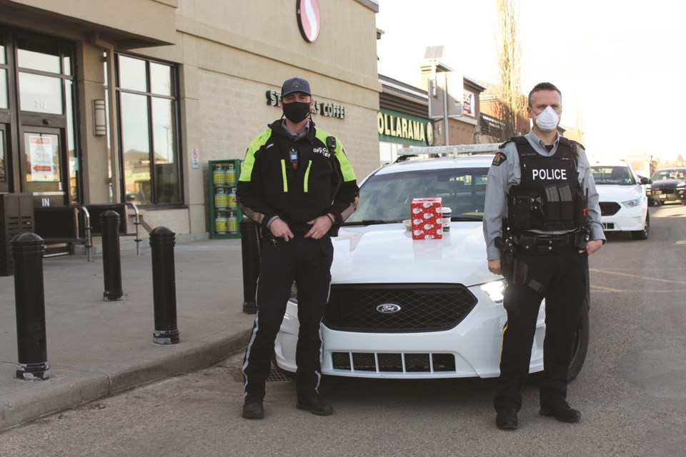 Airdrie RCMP and Municipal Enforcement officers were stationed outside three local grocery stores Dec. 5 to solicit donations for the Airdrie Lioness Club's Christmas hamper program. In total, the officers solicited about $1,550 in gift cards and $2,100 to support the program. Photo by Scott Strasser/Airdrie City View.