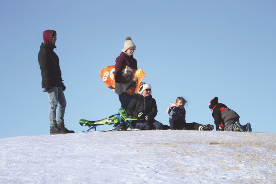A family in Crossfield enjoys an afternoon of sledding down the hill at Veterans Peace Park in early January. Photo by Scott Strasser/Rocky View Weekly