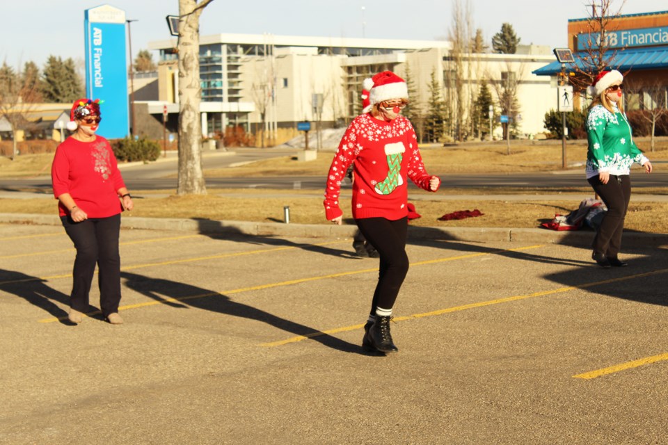 Members of Ladies Out Loud line-danced at the Towerlane Centre parking lot Dec. 5 to raise awareness of and funds for the Airdrie Lioness Club's Christmas hamper program. Photo by Scott Strasser/Airdrie City View.