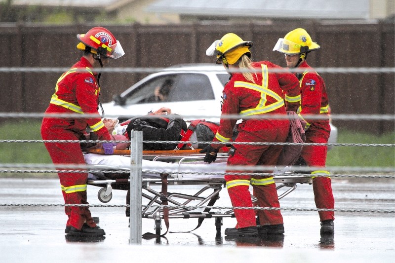 The driver of a Pontiac Sunfire receives medical attention after a single vehicle accident in Airdrie, May 27.