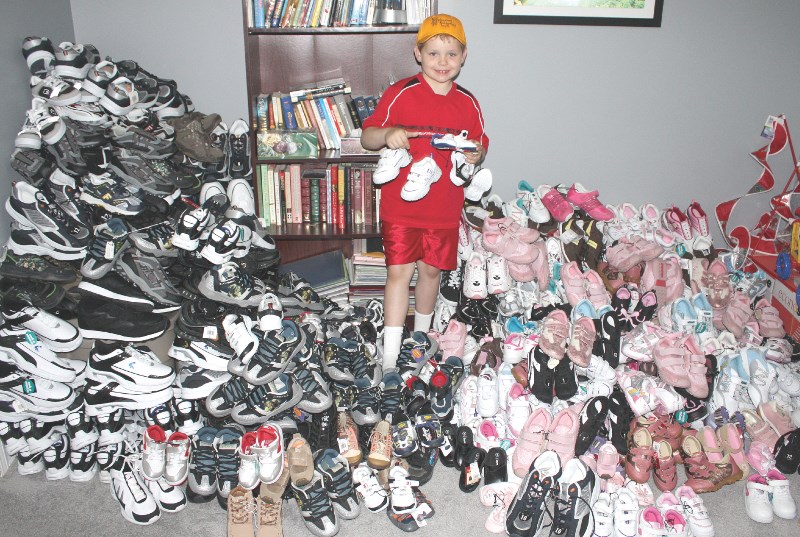 Stephen McPhee stands with hundreds of shoes raised for the Stephen&#8217;s Backpack Society Footprints campaign in 2008.