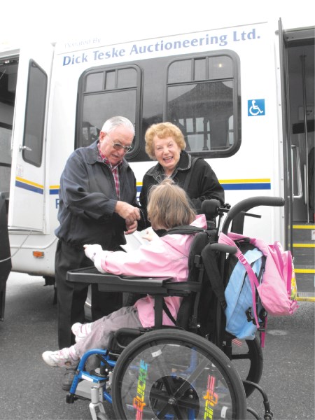 Dick Teske ceremonially hands over the keys to passenger Amy Drysdale as she arrived home from school on the new handibus..