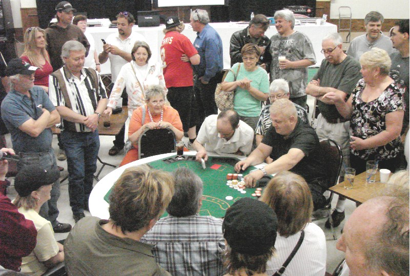 Airdrie resident Dale Aspholm (centre with the stack of chips) places a bet at the final table during Big Slick Regional Poker Final, held at the Ogden Legion on June 26.