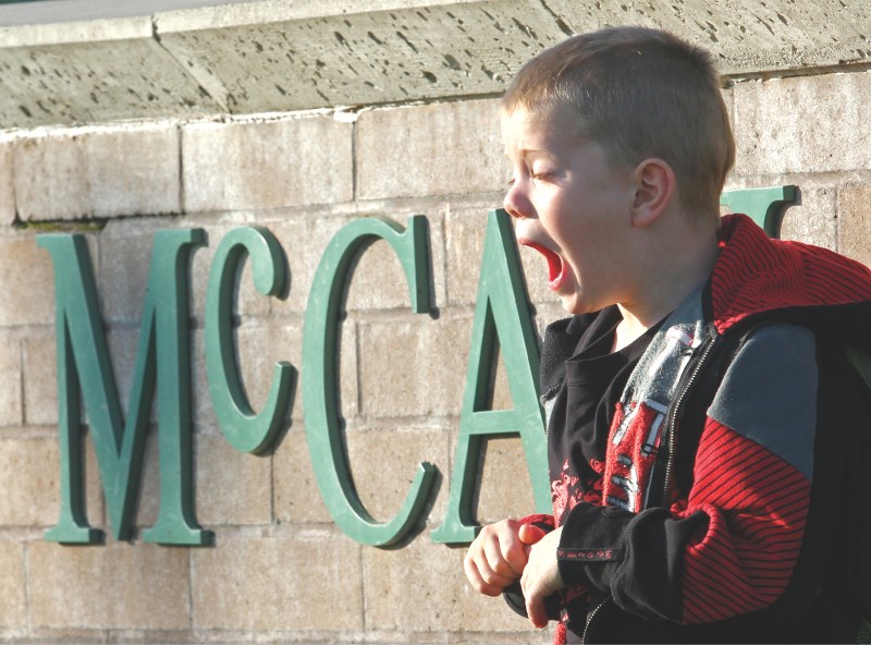 Five-year-old Dylan Cory yawns while standing in front of Ralph McCall on his first day of school, Aug. 19.