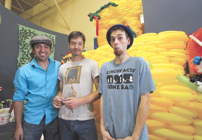 Airdrie artists Chris Burylo, Sam Bowman and Stephon Diachuk pose for photos while erecting the lost city of Eldorado out of balloons, Aug. 19 at the Airdrie Public Library.