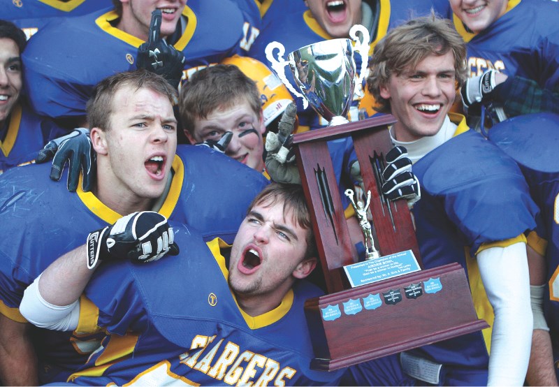 Members of the Bert Church Chargers football team celebrate their 17-9 Airdrie Bowl win over the crosstown rival George McDougall Mustangs, Oct. 15 at Genesis Place field.
