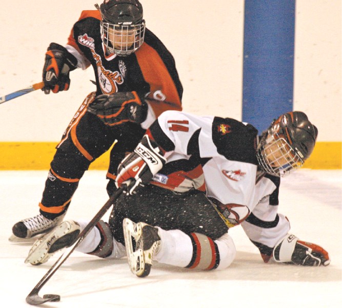 Xtreme forward Mackenzie Bauer fights for the puck against a Medicine Hat Hockey Hound defender during first period action of Airdrie&#8217;s 8-4 win, Oct. 17 at the Ron