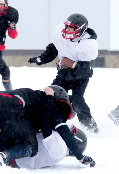 Northern Raiders&#8217; running back Josh Duazo tries to elude defenders during an intra-squad game at George McDougall, March 25.