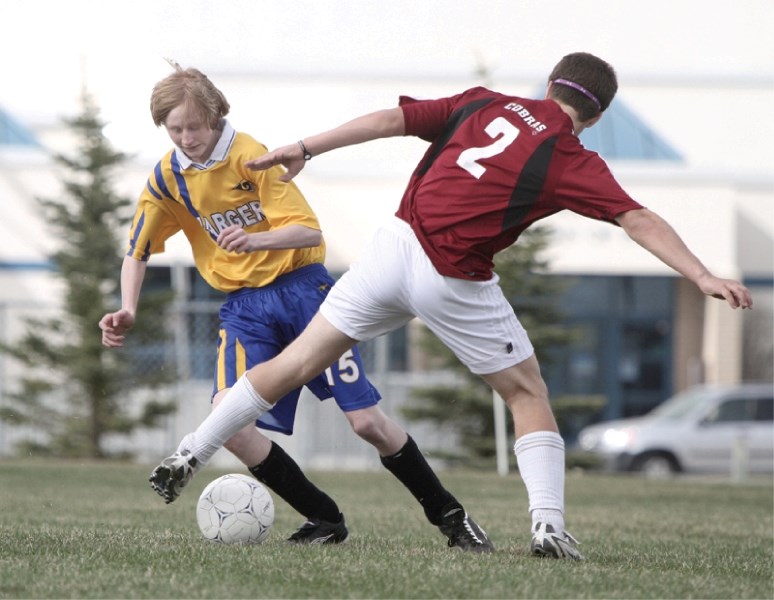 Bert Church Charger Blake Jeffrey (left) has his pocket picked by Cochrane Cobra Kellen Forrest during Cochrane&#8217;s 7-1 dismantling of the Bert Church club, May 12, at