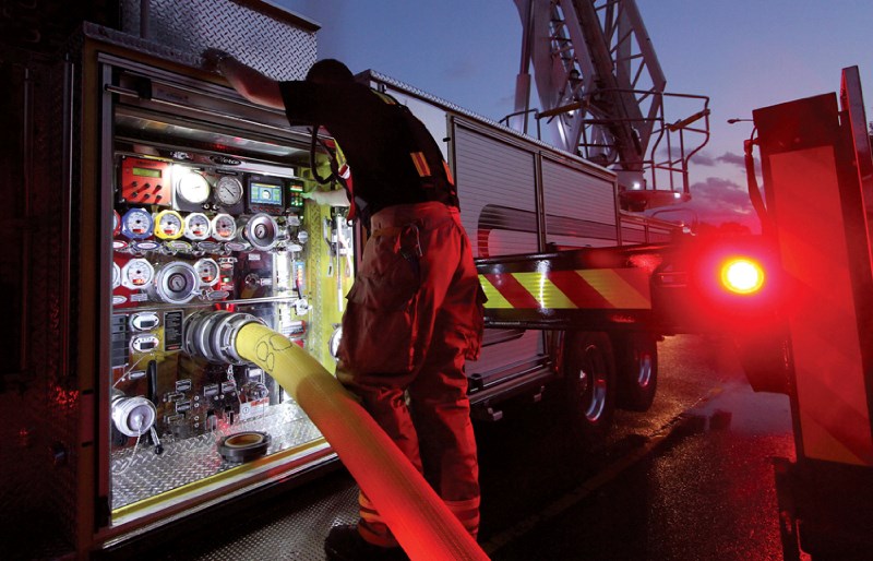 A member of the Airdrie Fire Department keeps an eye on the valves of a pumper truck during a single-home blaze in Big Springs, Aug. 3 at 9 p.m. The fire destroyed the house