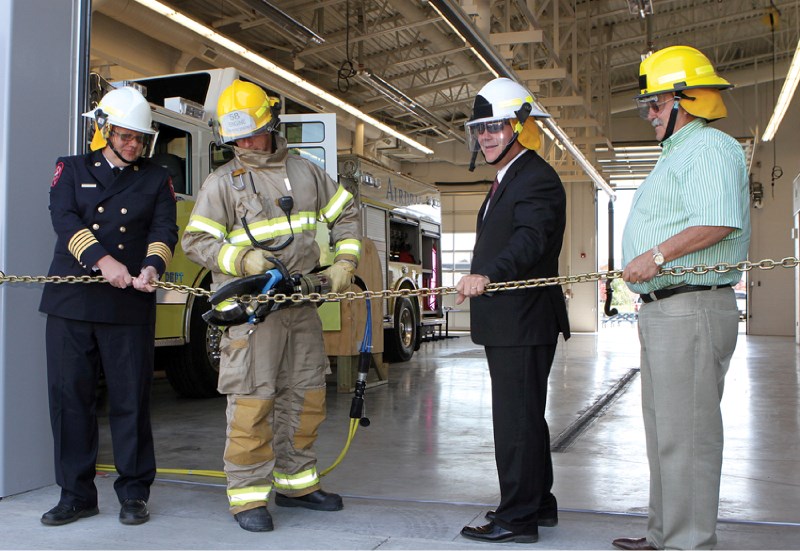 New Airdrie Fire Chief Kevin Weinberger, firefighter Ryan Coslovich, Airdrie Mayor Peter Brown and Alberta Transportation Minister Luke Ouellette use the Jaws of Life to