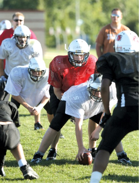 Quarterback Duncan Little, who stands 6&#8217;2&#8243; and is about to enter Grade 9, takes a snap during Airdrie Storm Bantam football practice, Aug. 16 at George McDougall