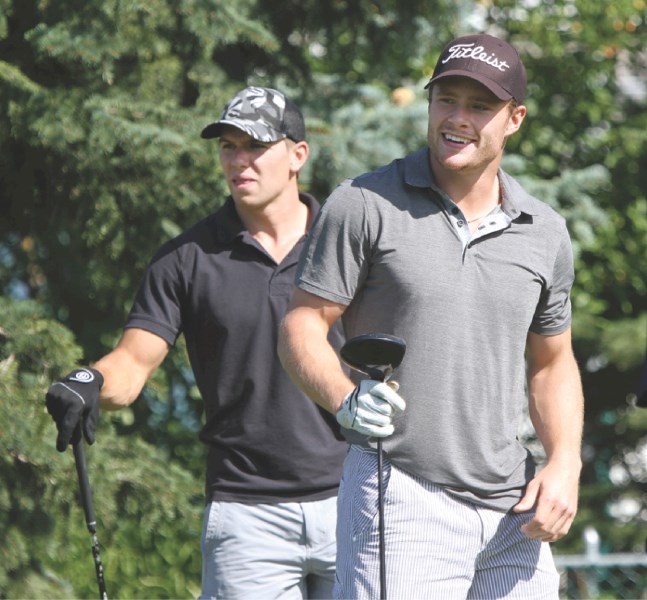 NHLers Zach Boychuk (left) and Dana Tyrell watch a drive during the 2011 Raise the Rinks Charity Golf Classic at Woodside Golf Course, Aug. 25.