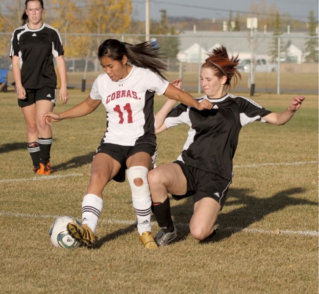 Mustang Bethany Jonker (right) battles for the ball with her Cochrane Cobras opponent, in the divisional championship game, Oct. 11, at the Monklands Soccer Park in Airdrie.
