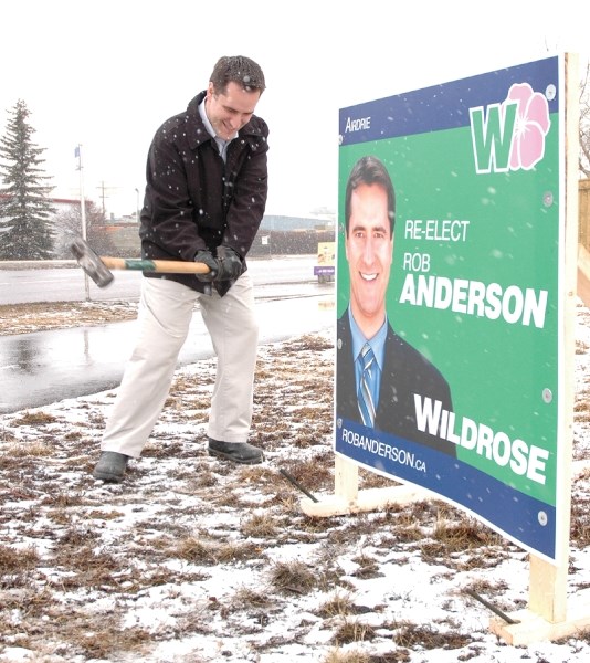 Incumbent MLA Rob Anderson, running for the Wildrose party in this spring&#8217;s provincial election, hammers a stake through a sign along East Lake Boulevard, March 26. .