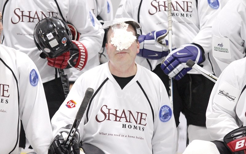 Mayor Peter Brown reacts to getting a pie in the face, courtesy of ex NHLer Dennis Polonich, during a first period photo break at the ARRES Winter Challenge at the Ron