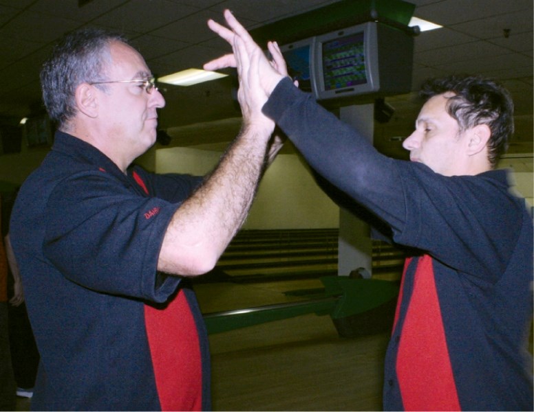 Daniel St-Laurent, bowling coach for Airdrie&#8217;s Special Olympics program celebrates as one of his athletes picks up a spare.