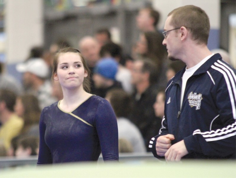 Airdrie Edge gymnast Caitlin Brown speaks with coach Jamie Atkin after her double-mini trampoline routine April 6